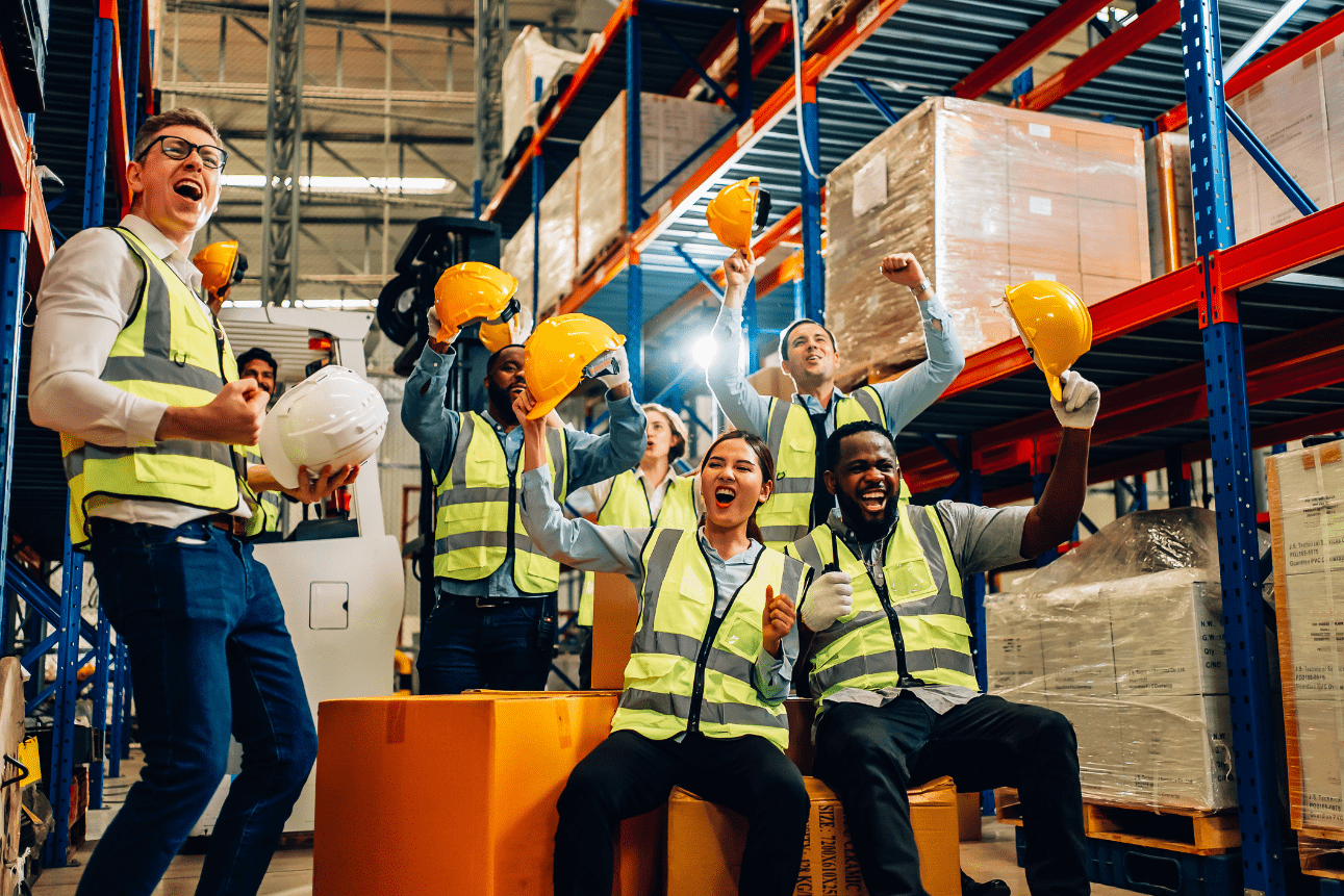 Professional warehouse workers celebrating logistics success—highlighting the benefits of supply chain resilience in a warehouse setting.